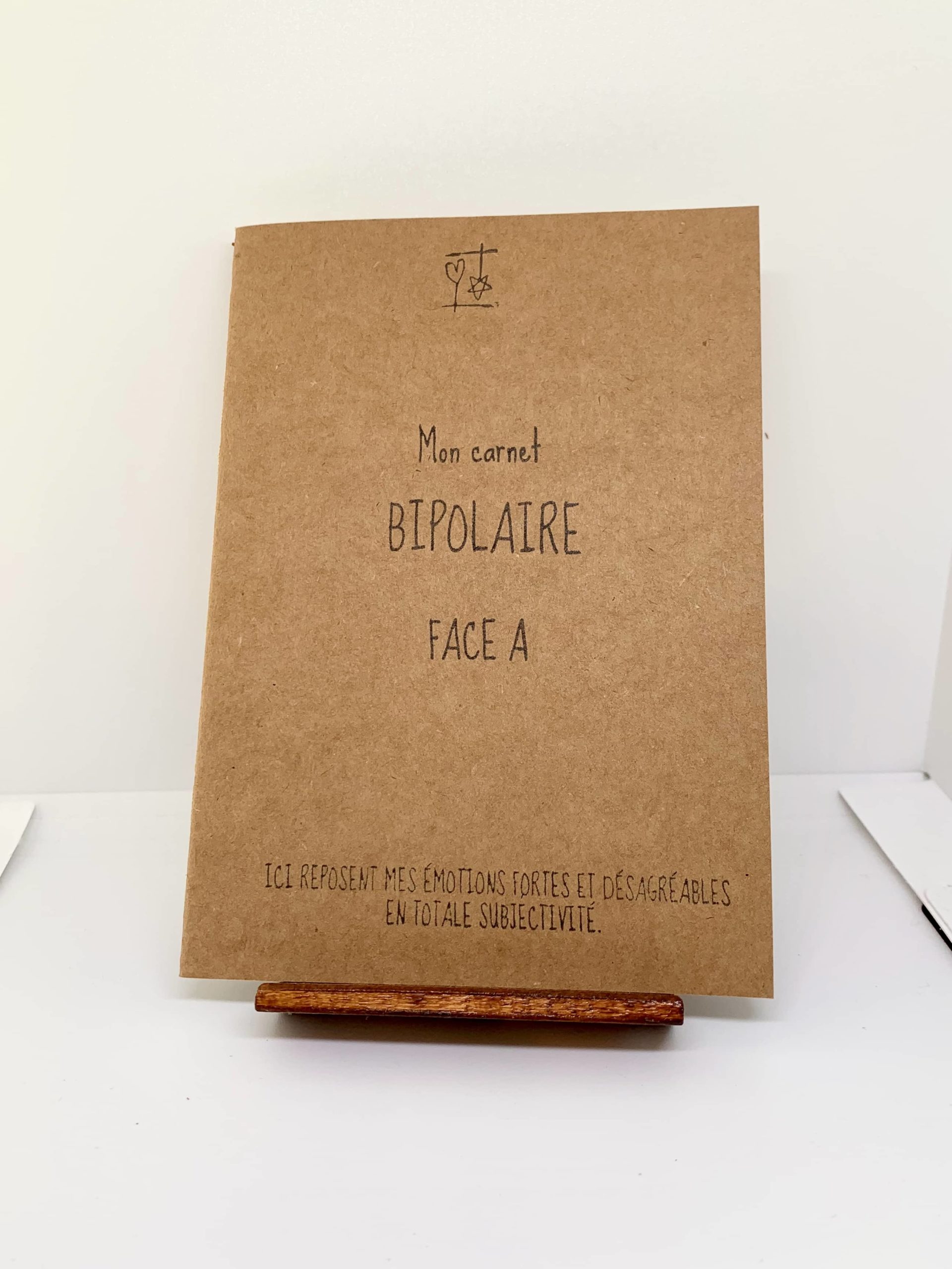 Couverture de Mon carnet BIPOLAIRE - Face A - Ici reposent mes émotions fortes et désagréables en totale subjectivité. Mon carnet BIPOLAIRE fait partie des Carnets d'Expression de la collection "Le Cœur sur terre et la tête dans les étoiles". Distribution Du Baume Aux Cœurs - Concept store - Créations originales inspirantes. Créons des aujourd'hui pour mieux vivre demain. ACCOMPAGNEMENTS ATYPIQUES | CURIOSITÉS POÉTIQUES | ANIMATIONS CRÉATIVES www.ame-expressive.fr