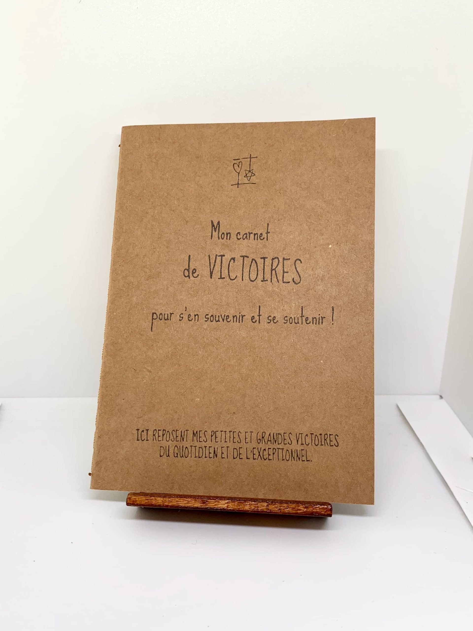 Couverture de Mon carnet de Victoires - pour s’en souvenir et se souvenir ! Mon carnet de VICTOIRES fait partie des Carnets d'Expression de la collection "Le Cœur sur terre et la tête dans les étoiles". Distribution Du Baume Aux Cœurs - Concept store - Créations originales inspirantes. Créons des aujourd'hui pour mieux vivre demain. ACCOMPAGNEMENTS ATYPIQUES | CURIOSITÉS POÉTIQUES | ANIMATIONS CRÉATIVES www.ame-expressive.fr